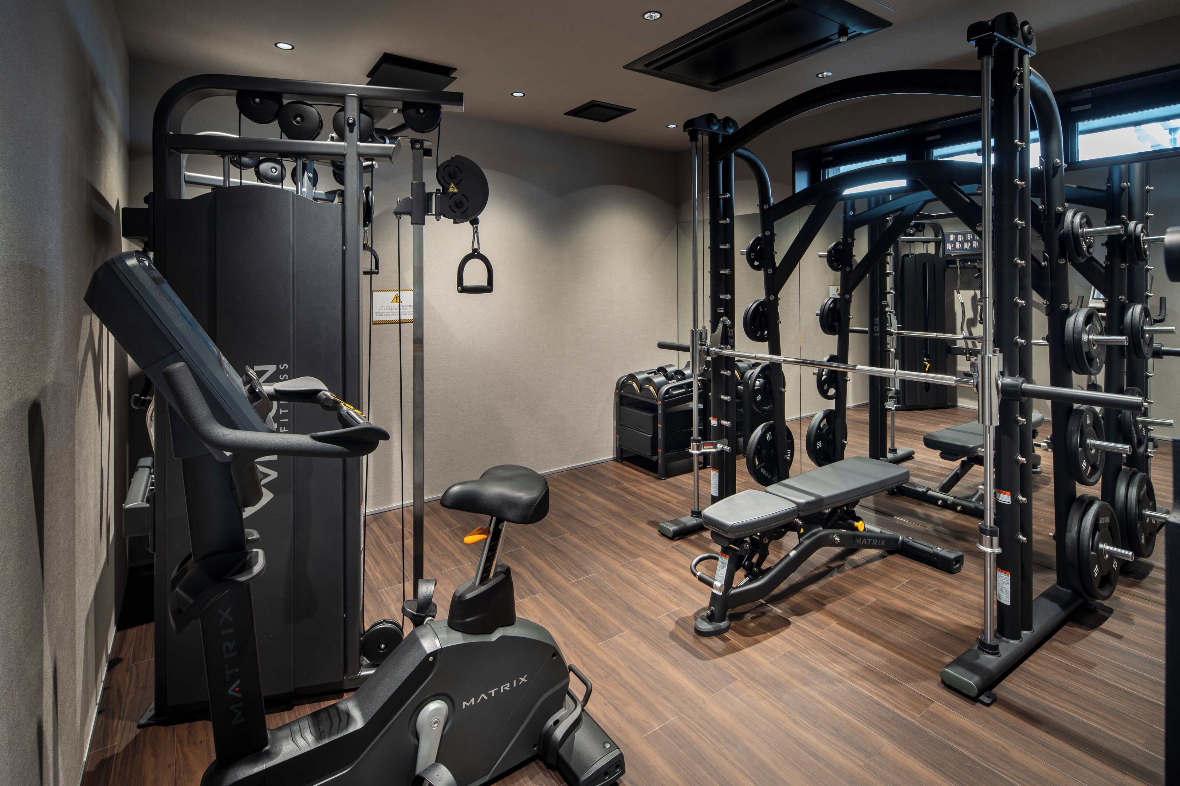 A gym with cardio machines, weightlifting equipment, and benches.