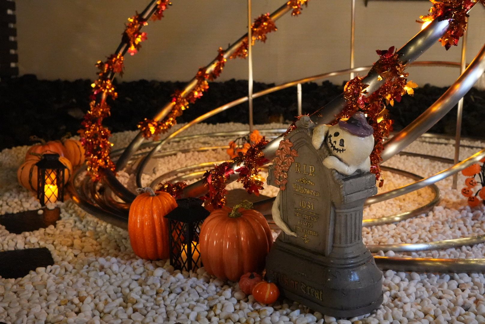 A decorative Halloween setup with a tombstone, pumpkins, and a jack-o'-lantern.