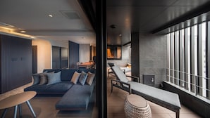 A modern interior with a sofa, lounge chairs, and a view through a glass partition. - KOHAKU Apartment Hotel Kyoto (Kyoto)