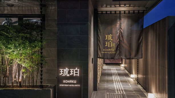 A hotel entrance with a sign reading 'KONAKU APARTMENT HOTEL KYOTO' and a pathway leading inside. - KOHAKU Apartment Hotel Kyoto (Kyoto)