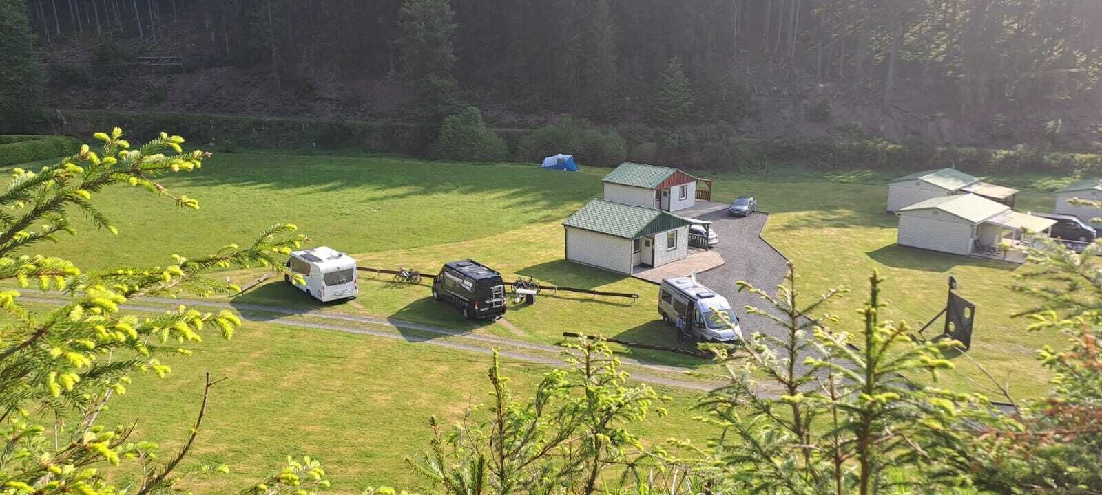 Un terrain de camping équipé de mobil-homes, d’un hélicoptère et de petits chalets.