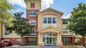 A hotel with a central entrance, a red and beige facade, and a sign indicating '6 suites'. - 1 King Bed | Suite, Nsmk, Kitchen, Sofa-Bed (Jacksonville)