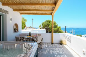 Terraza en la azotea con jacuzzi, zona de comedor y vista al mar.