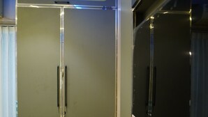 Un interno moderno con un ampio armadio, una televisione a schermo piatto e un pavimento chiaro.