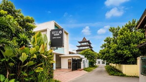 A hotel named AIRIS HOME with a traditional pagoda-style building in the background.