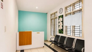 A reception area with a reception desk, a clock, and a seating area with chairs.