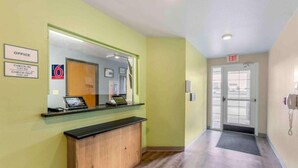 A hotel reception area with a check-in/check-out counter, a mirror, and an exit door. - 2 Queen Beds |Non-Smoking, Kitchen (El Paso TX)
