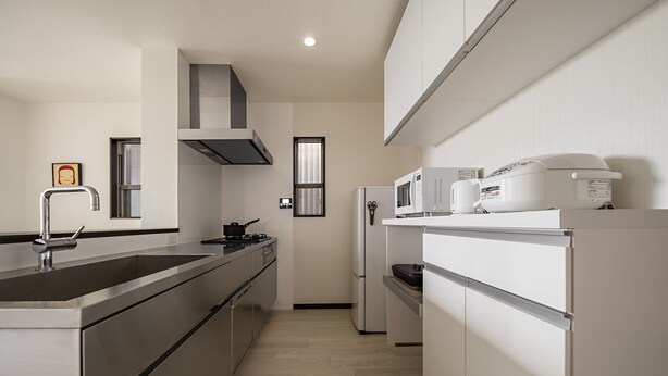 Una cucina moderna con elettrodomestici in acciaio inossidabile, forno ventilato e microonde.