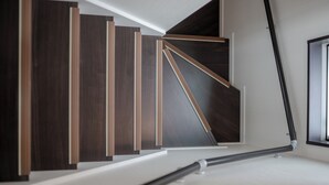 Una moderna scala con pannelli in legno scuro e una ringhiera in metallo dal design elegante.