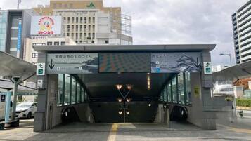 A modern train station entrance with clear signage, a covered waiting area, and a visible platform.