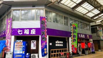 A commercial building with a purple storefront, vending machines, and a covered entrance.