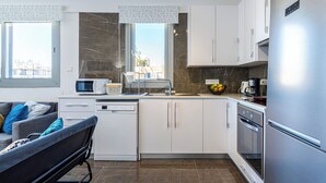 A modern kitchen with white cabinets, a stainless steel refrigerator, a microwave, and a coffee maker. - Kmeidos 1-BR Apt & Balcony in Larnaca (Larnaca)