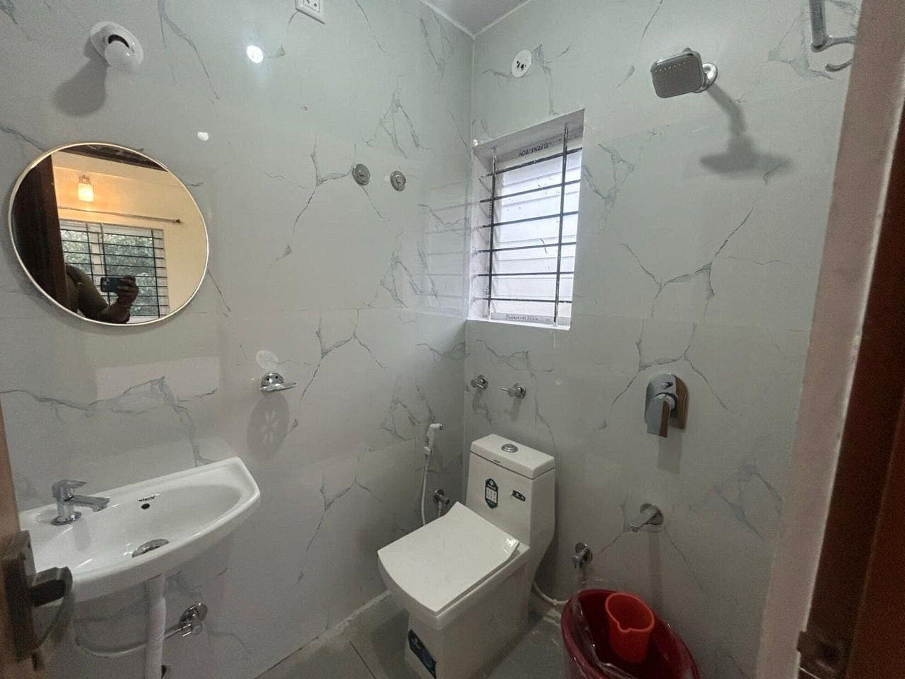 Une salle de bain avec un lavabo, des toilettes et un miroir.