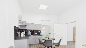 A compact living space with a kitchenette, a dining area, and a seating area. - Compact city apartment for 2 people (GÖ02) (Görlitz)