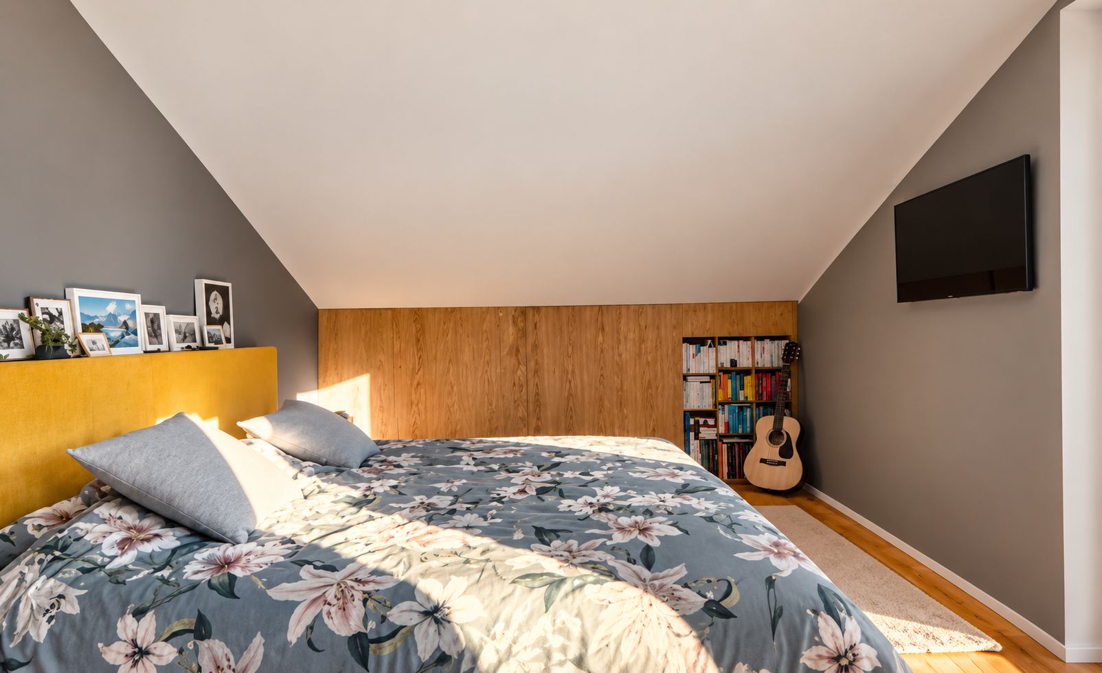 Ein Schlafzimmer mit einem Bett, einem Bücherregal und einer Gitarre.