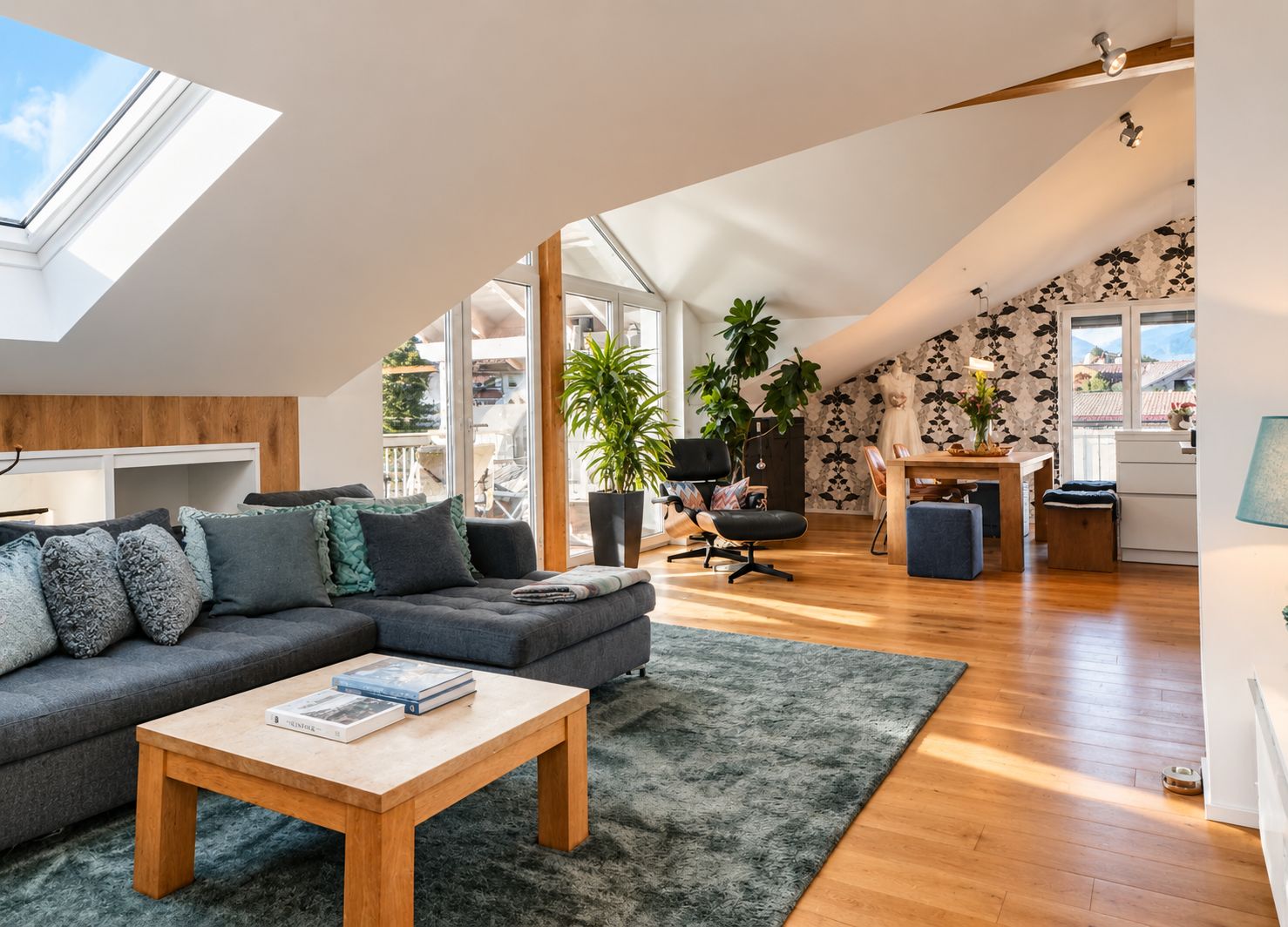Un loft moderno con un tragaluz grande, una zona de estar acogedora, un comedor y vistas al exterior.