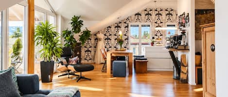 A spacious loft with a high ceiling, a dining area, and a kitchen.