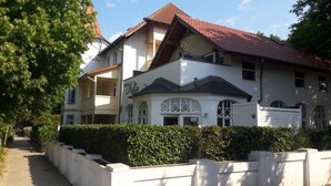 A two-story house with a red-tiled roof, white exterior walls, and a white front door. - Vacation apartment S22 - Holiday apartment S22 with terrace and WLAN in Graal-Müritz (Graal-Müritz)