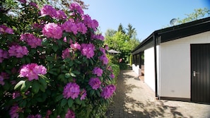 A pathway leading to a building with a white exterior and a dark door. - Vacation home Reidschott - Holiday home Reidschott - modern, cozy and (Wyk auf Föhr)