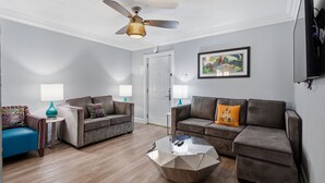 A modern living room with two sofas, a coffee table, and a ceiling fan. - Elegant 2BR on Frenchmen Street with shared pool, hot tub, and easy walk to the French Quarter. (New Orleans)