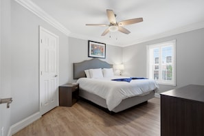 A bedroom with a bed, nightstand, ceiling fan, window, and artwork. - Elegant 2BR on Frenchmen Street with shared pool, hot tub, and a short walk to the French Quarter. (New Orleans)