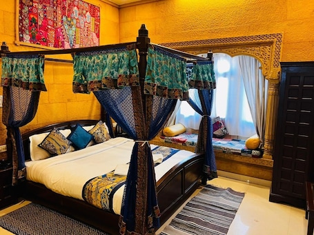 Una cama con dosel, una mesita de noche y una ventana con cortinas.