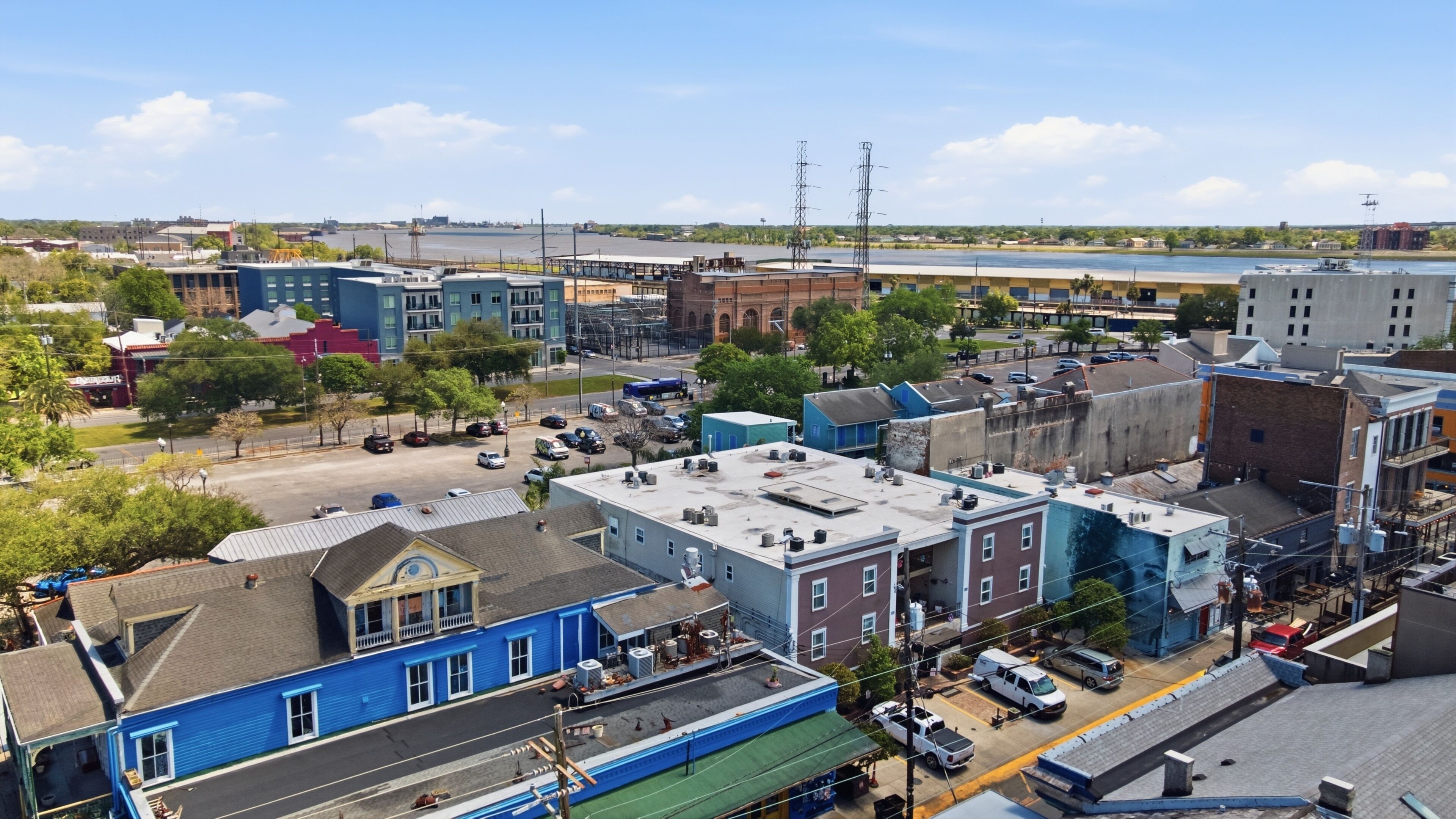 A cityscape with various buildings, including a blue building with a flat roof and a red building with a brick facade.
