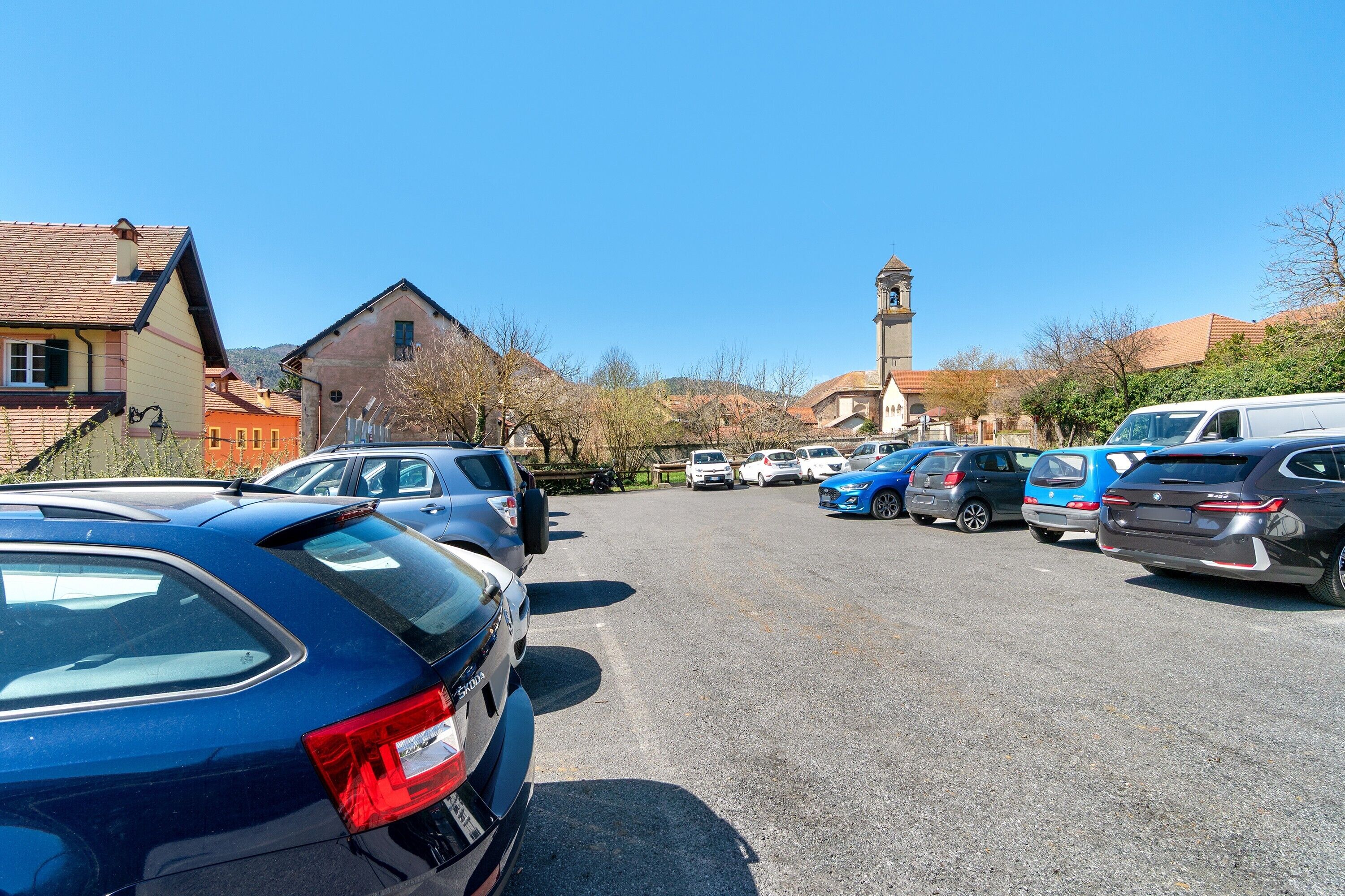 A parking lot with cars, a church, and buildings in the background.
