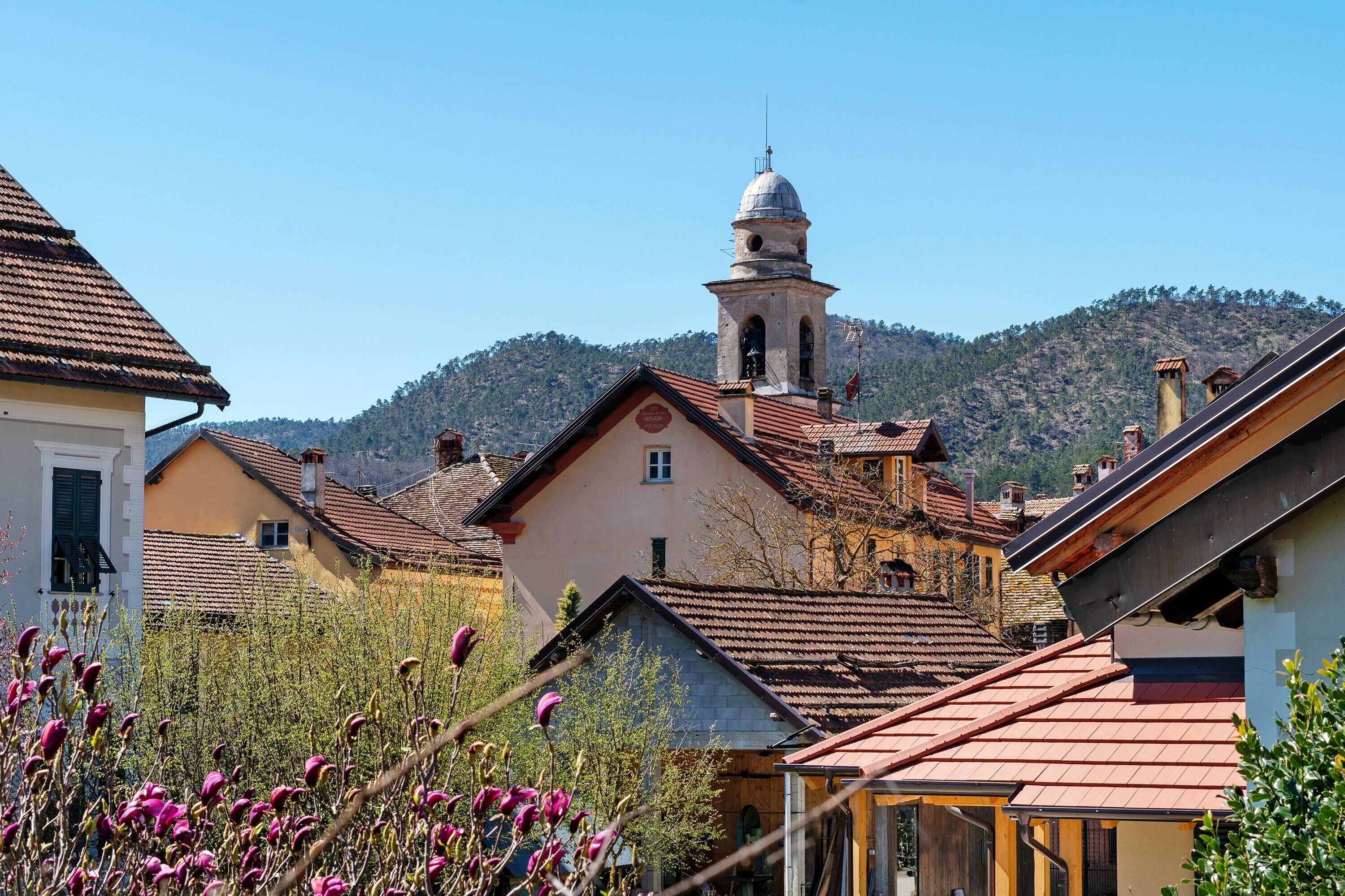 Un pueblo con arquitectura tradicional, que incluye una iglesia con campanario y un edificio de techo inclinado.
