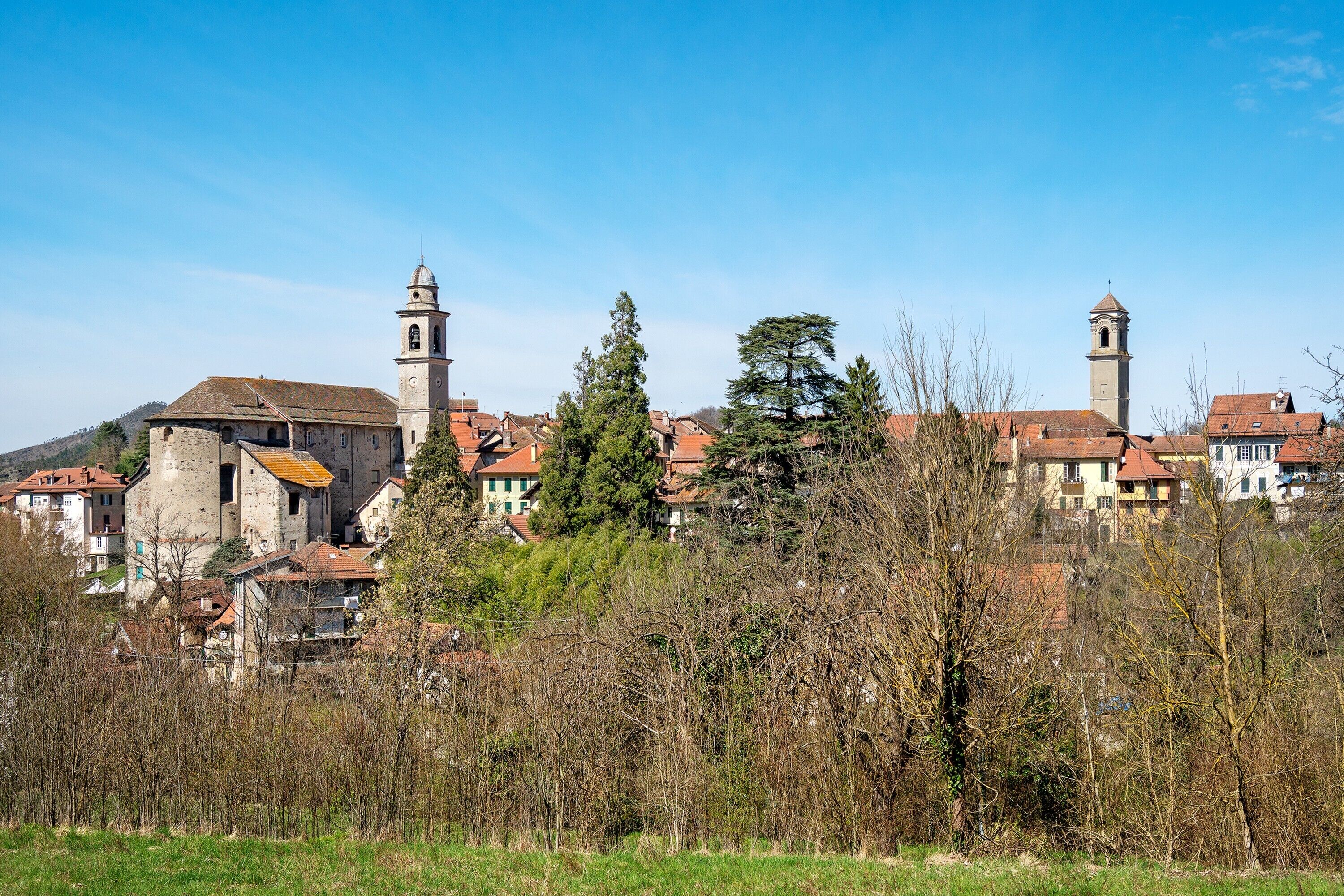 Eine historische Stadt mit Steinbauten, einem markanten Turm und einer Kirche mit Glockenturm.