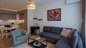 A modern living room with a grey sofa, a teal armchair, and a coffee table. - Belgrade Waterfront Lux 2 (Belgrade)