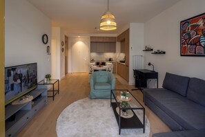 Apartamento Deluxe, vistas a la ciudad | Zona de estar | Smart TV de 50 pulgadas con canales por cable