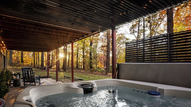 A hot tub under a wooden pergola with a view of autumn trees. - Huckleberry Hills | Hot Tub & Fire Pit & Dogs (Harpers Ferry)