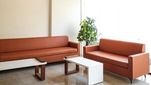 Una sala de estar moderna con un gran ventanal, un sofá, una mesa de centro y una lámpara decorativa en el techo.