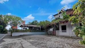 A courtyard with a thatched-roof structure, a white building with a balcony, and a sign reading 'ADA KAMAR'. - Hotel O near Supermall Karawaci formerly (Tangerang)