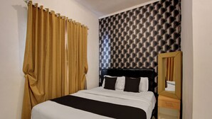 A hotel room with a bed, a bedside table, a mirror, and a wall with a textured pattern. - Hotel O near Supermall Karawaci formerly (Tangerang)