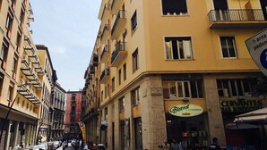A narrow street with multi-story buildings, a bar named 'Bistro Cervantes,' and a sign indicating a pedestrian area.