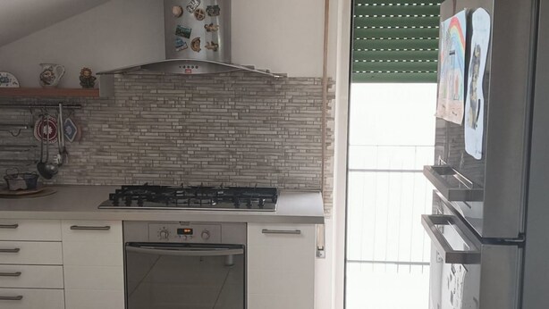 Une cuisine équipée d’une cuisinière à gaz, d’un four et d’appareils électroménagers en acier inoxydable.