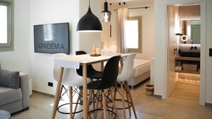 Un espai de vida modern amb zona de menjador, sofà, llit i cuina.