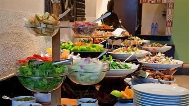 A buffet with various dishes including salads, fruits, and other food items. - African Regent Hotel (Accra)