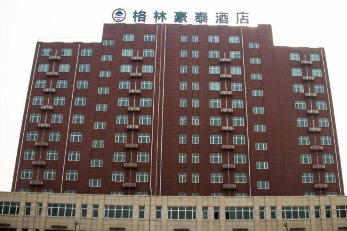 A multi-story hotel building with a red facade and numerous windows.