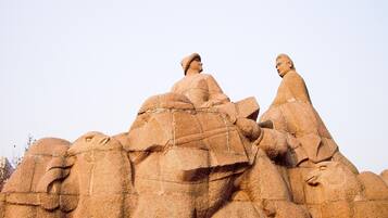 A large rock formation with carved figures.