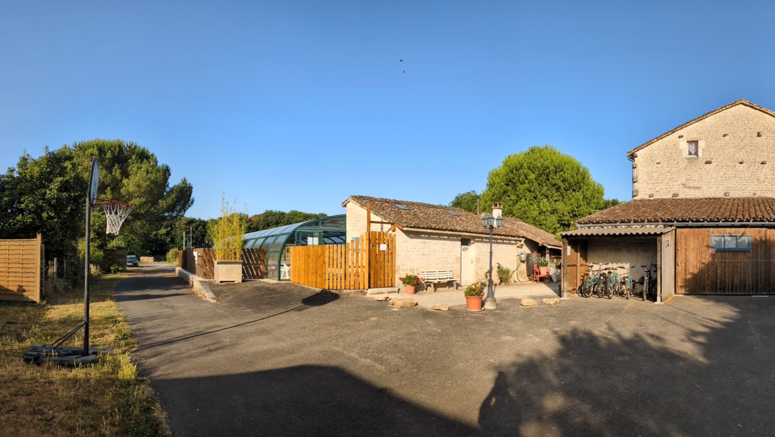 Un paysage rural avec un petit bâtiment, une clôture en bois et un vélo.
