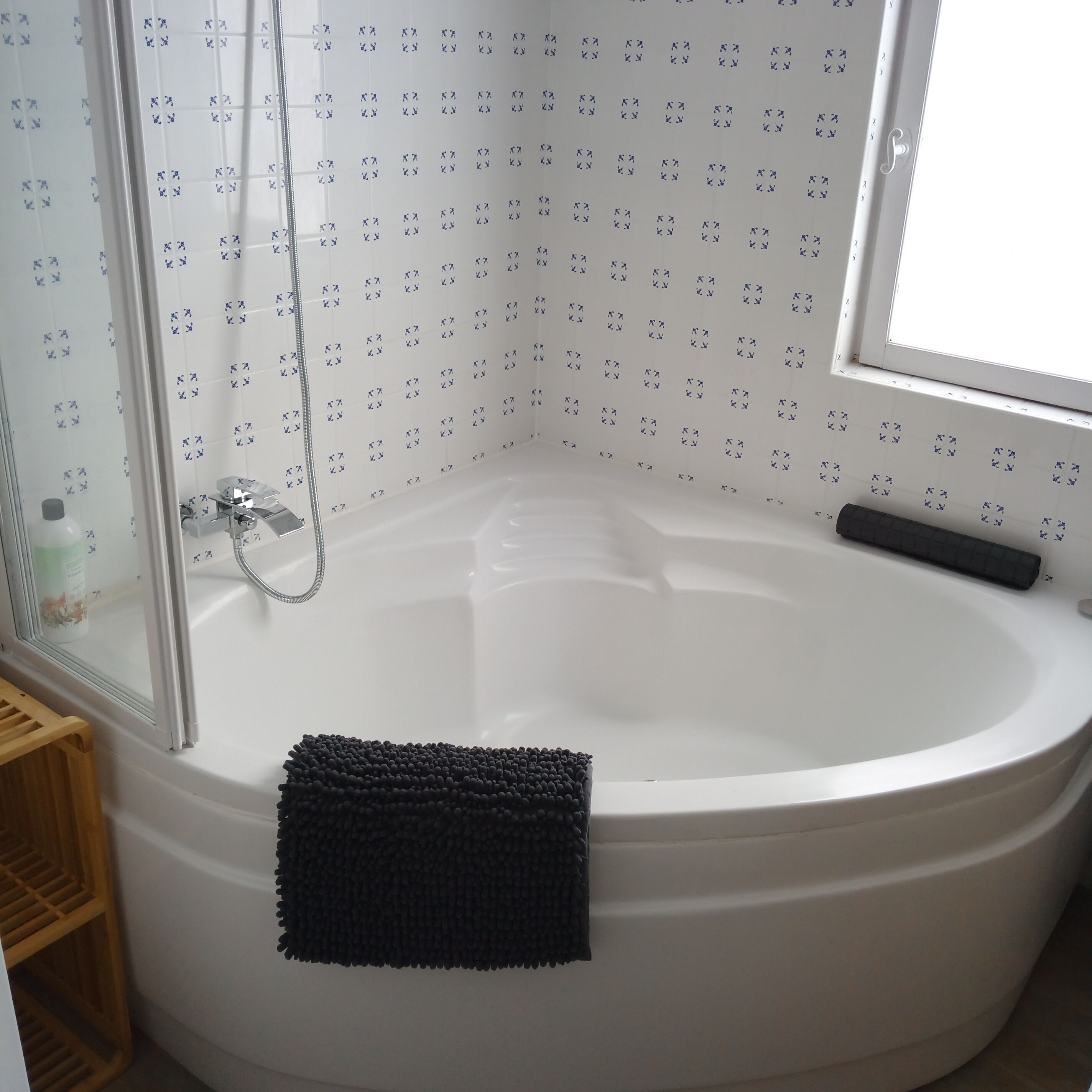 Un bagno con una vasca, una doccia e una finestra.
