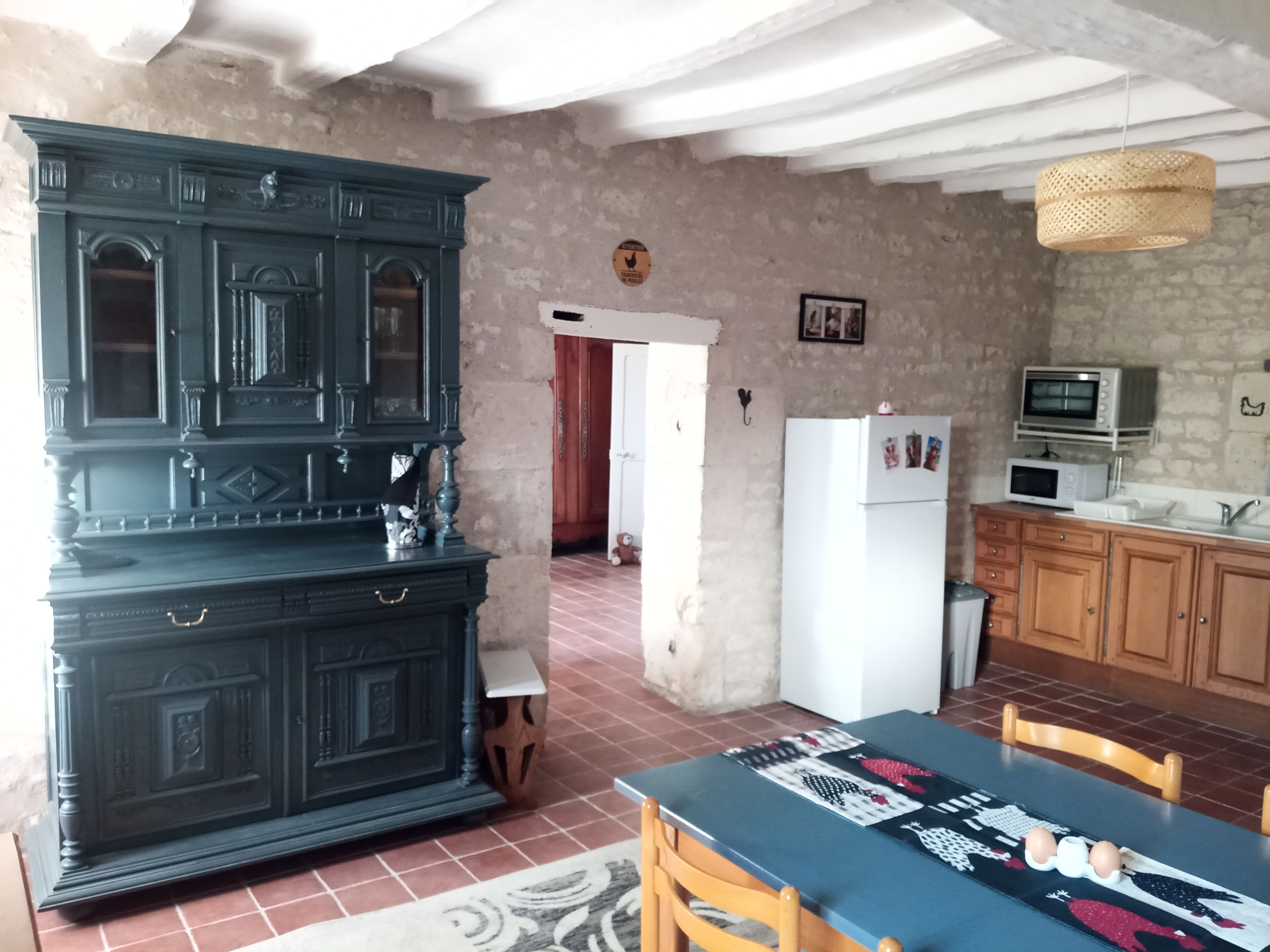 A kitchen with a dark wooden cabinet, a white refrigerator, a microwave, and a sink.