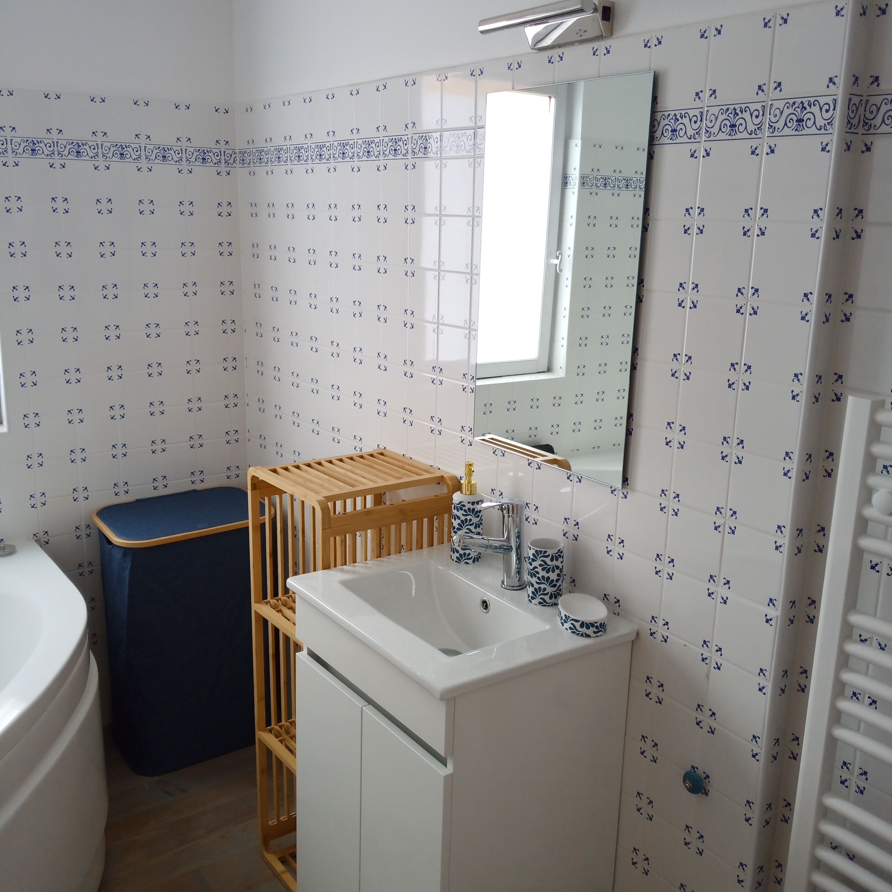 A bathroom with a white sink, mirror, and patterned tiles.