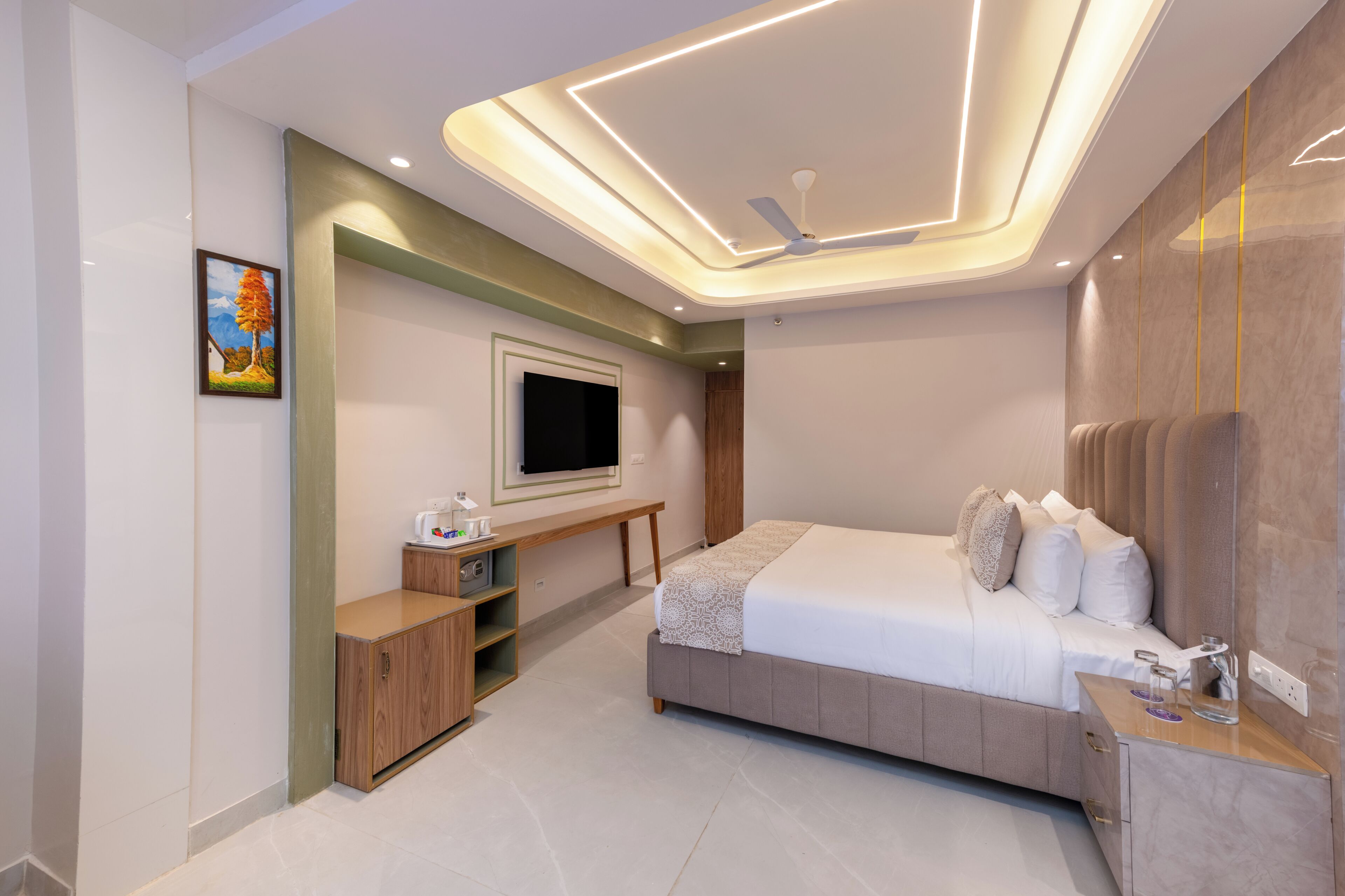 A modern bedroom with a bed, bedside table, TV, and built-in shelving.