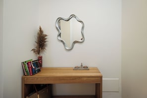 A wooden table with a mirror, books, and a decorative item on it. - Etherio Naxos Anemos Tranquil 2-bedroom apartment with AC in beautiful Naxos (Naxos)