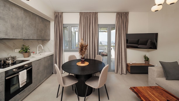 A modern kitchen with a dining table, chairs, and a TV mounted on the wall. - Etherio Naxos Anemos Tranquil 2-bedroom apartment with AC in beautiful Naxos (Naxos)