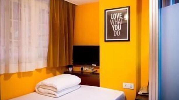 A hotel room with a bed, a TV, a framed motivational quote on the wall, and a window with curtains. - Tempo Inn @david Mansion (Kowloon)